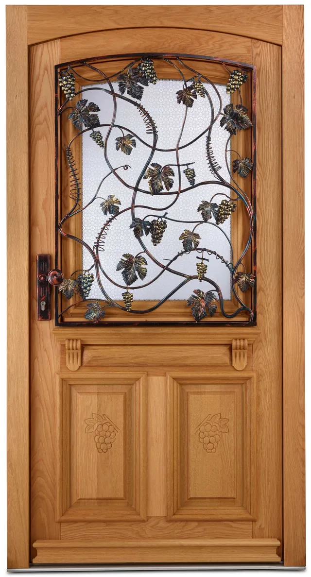 Haustür aus massiver Eiche mit einem Ziergitter aus Weinranken, Blättern und Trauben vor dem Glas und geschnitzten Trauben in den Füllungen